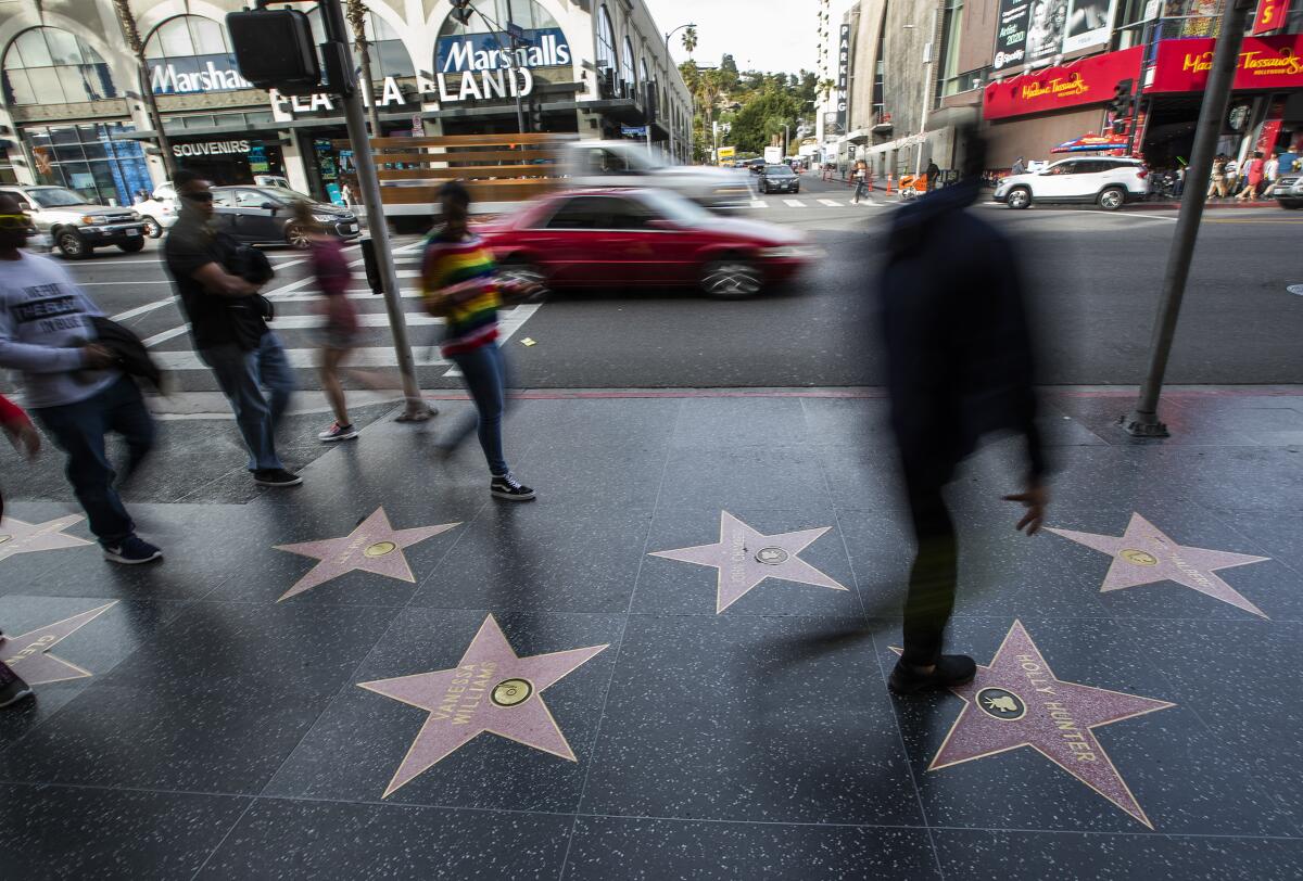 Pedestrians walk along the Hollywood Walk of Fame