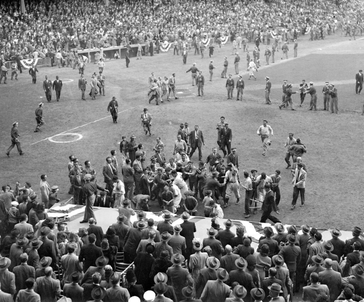 Fans swarm the Yankee Stadium field after the Yankees' World Series title victory over the Brooklyn Dodgers.