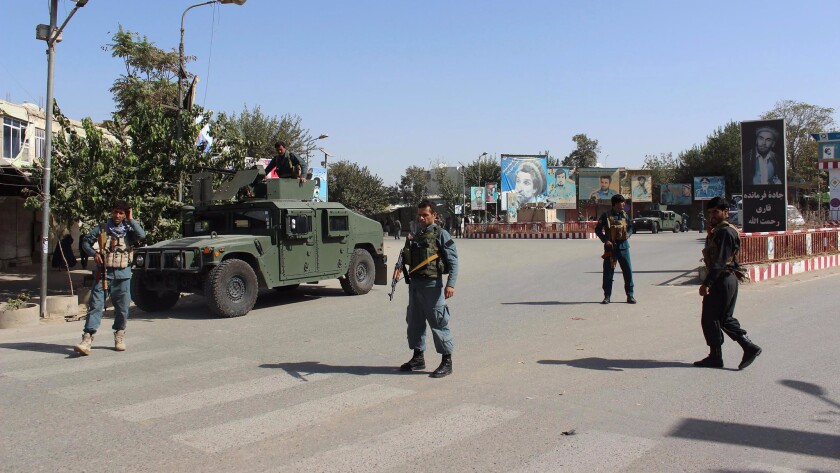 Afghan police stand guard during fighting between Taliban militants and Afghan security forces in Kunduz on Monday.