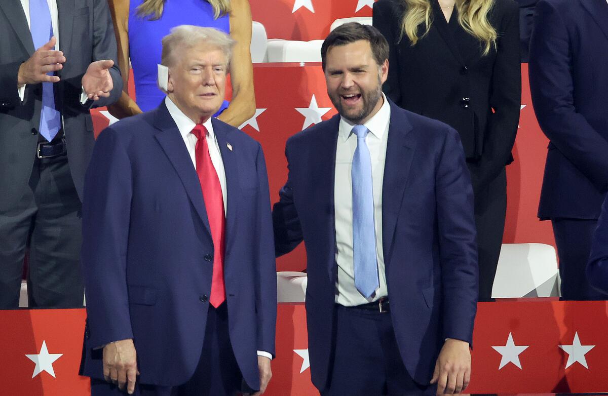 Former president Donald Trump talks to running mate Sen. J.D. Vance at the Republican National Convention.