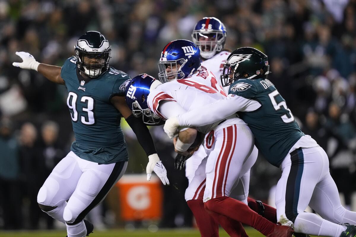 Giants quarterback Daniel Jones is hit by Eagles defensive end Brandon Graham, right, during the second half Jan. 21, 2023.