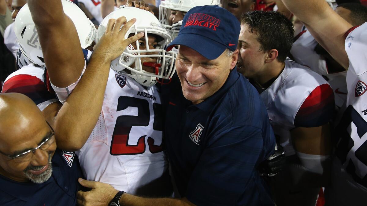 Arizona Coach Rich Rodriguez, right, celebrates with wide receiver Austin Hill and other Wildcats players following a 49-45 victory over California on Sept. 20.