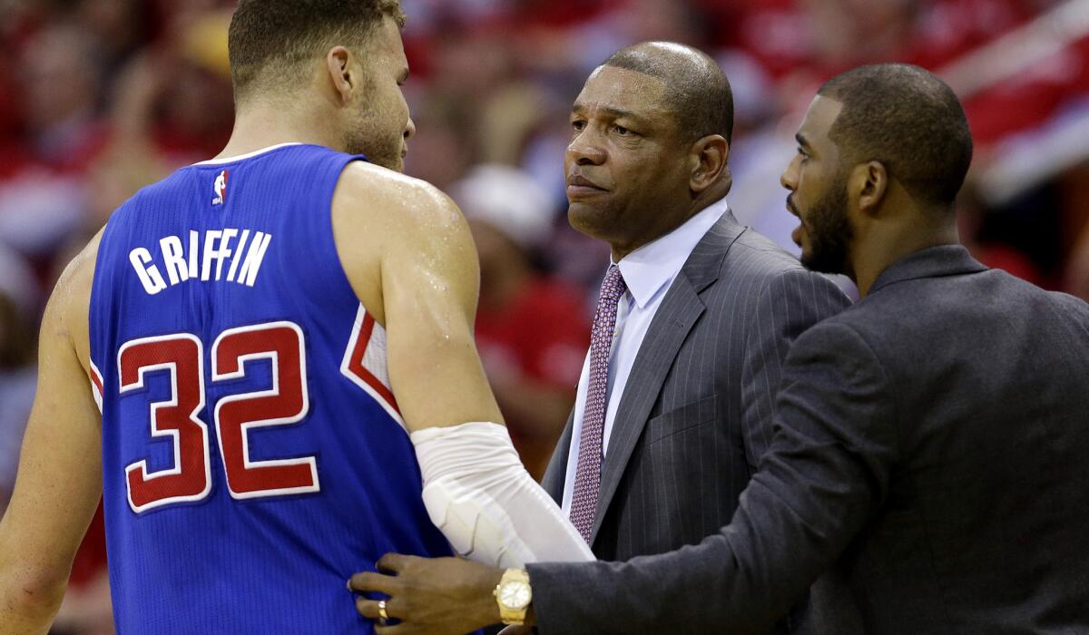 Chris Paul, right, talks to teammate Blake Griffin and Coach Doc Rivers on the sideline during the second half of Wednesday's playoff game against the Rockets in Houston.