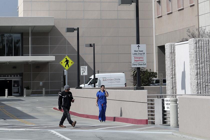 People walk between hospital wings at Adventist Health Glendale in Glendale on Friday, March 6, 2020.