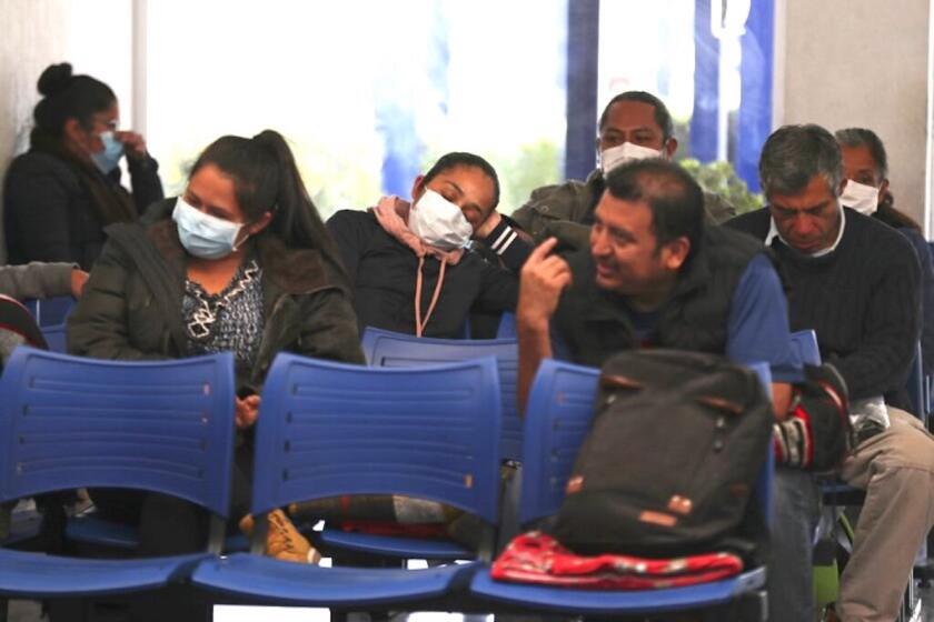 Algunas personas con mascarillas esperan su turno en un hospital mexicano que se especializa en enfermedades respiratorias, INER, en Ciudad de México.