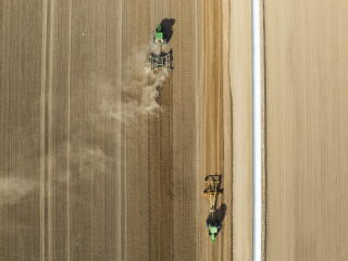 Farm vehicles work an alfalfa field owned by the company Fondomonte, in Vicksburg, Ariz.