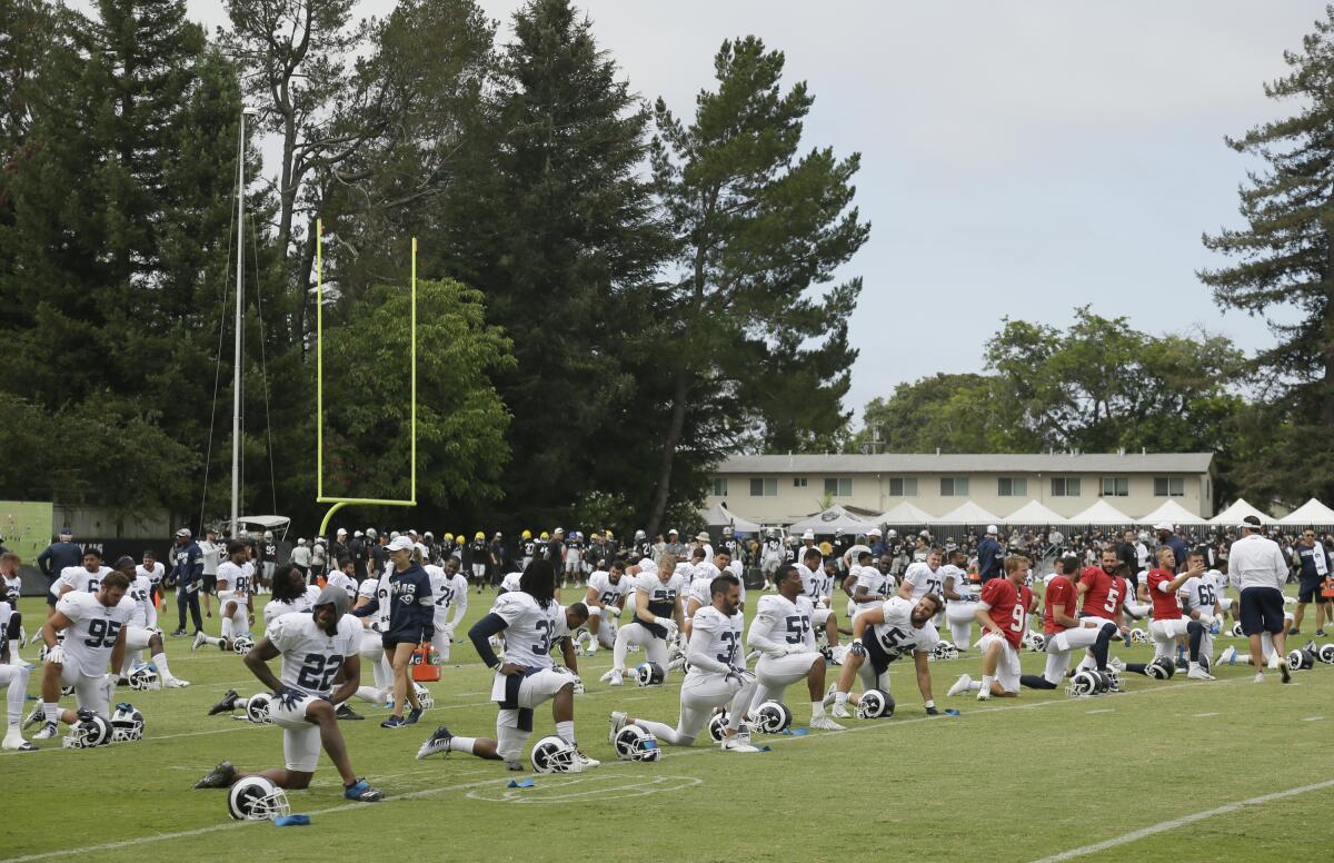 Rams players stretch during training camp on Wednesday in Napa. The Oakland Raiders and the Rams held a joint practice.