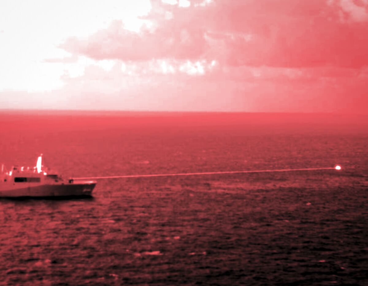In this handout infrared photo from the U.S. Marine Corps, the USS Portland fires a laser weapon system at a target floating in the Gulf of Aden on Tuesday, Dec. 14, 2021. The U.S. Navy announced Wednesday it tested a laser weapon and destroyed a floating target in the Mideast, a system that could be used to counter bomb-laden drone boats deployed by Yemen's Houthi rebels in the Red Sea. (Staff Sgt. Donald Holbert/U.S. Marine Corps via AP)