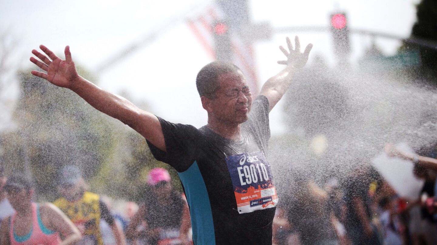Marathon runners find comfort in a cold water spray as they make their way towards Rodeo Drive in Beverly Hills.