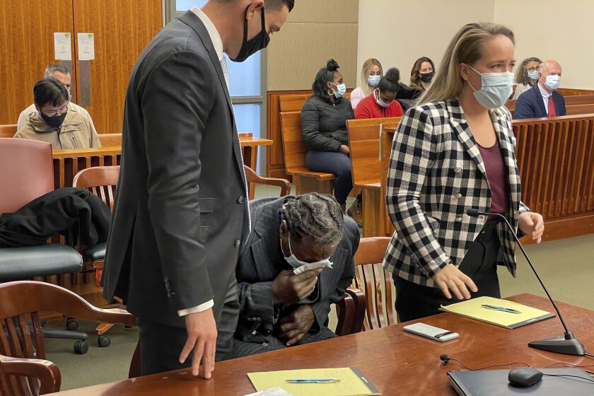 Anthony Broadwater breaks down crying Monday, Nov. 22, 2021, in Syracuse, N.Y., when a judge overturned his 40-year-old rape conviction. With him are his lawyers David Hammond (left) and Melissa Swartz. Broadwater, who spent 16 years in prison, was cleared Monday by a judge of raping Sebold when she was a student at Syracuse University, an assault she wrote about in her 1999 memoir, "Lucky." (Katrina Tulloch/The Post-Standard via AP)