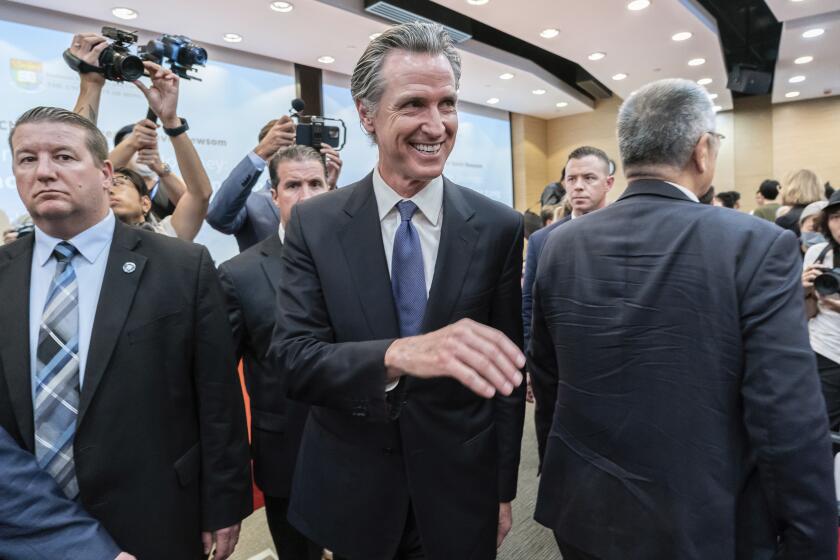 California Gov. Gavin Newsom, center, leaves the lecture hall after attending the fireside chat at the Hong Kong University in Hong Kong, Monday, Oct. 23, 2023. The Governor of California said on Monday his state will always be a partner on climate issues no matter how the U.S. presidential election next year turns out during his week-long trip to China, in an attempt to reinforce his region's role as a global leader on climate change. (AP Photo/Anthony Kwan)