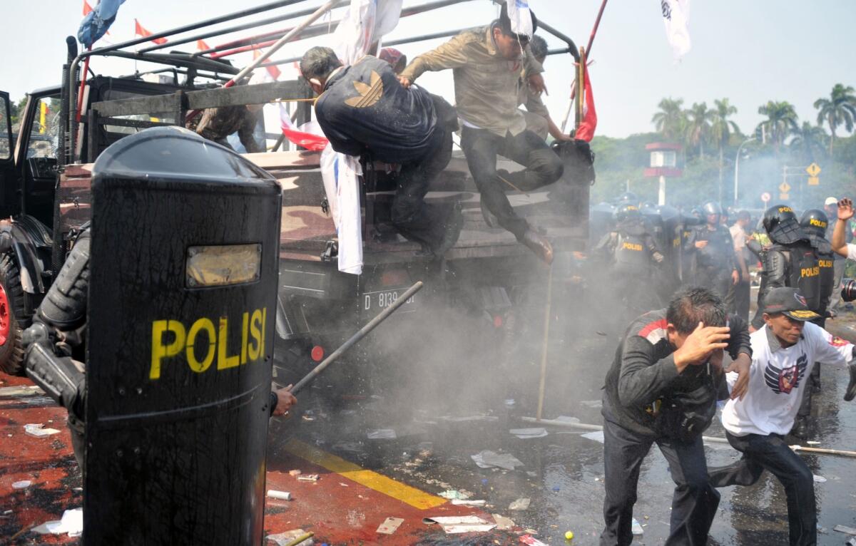 Indonesian anti-riot police move in to arrest supporters of presidential candidate Prabowo Subianto as they try to pass a blockade near the Constitutional Court in Jakarta on Thursday.