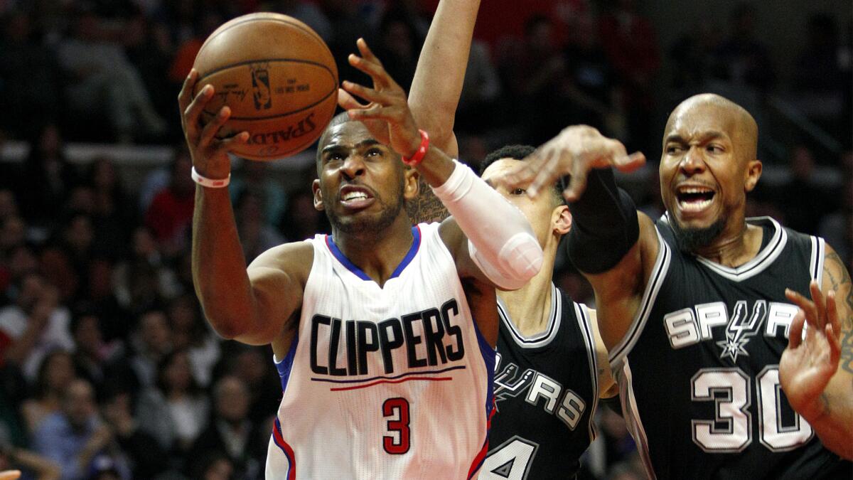 Clippers guard Chris Paul drives to the basket against Spurs guard Danny Green (14) and forward David West (30) in the fourth quarter.