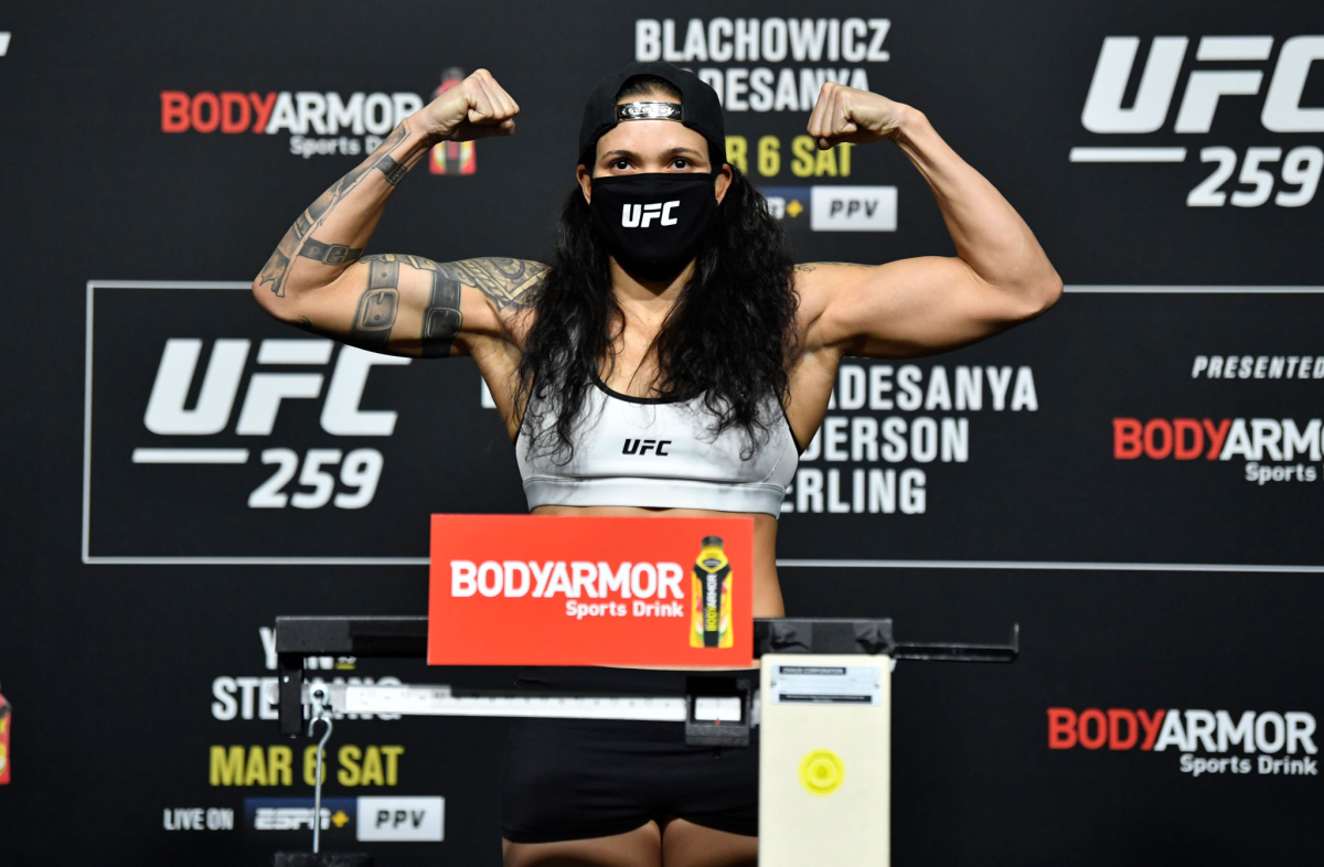 Amanda Nunes poses on the scale during the UFC 259 weigh-in.
