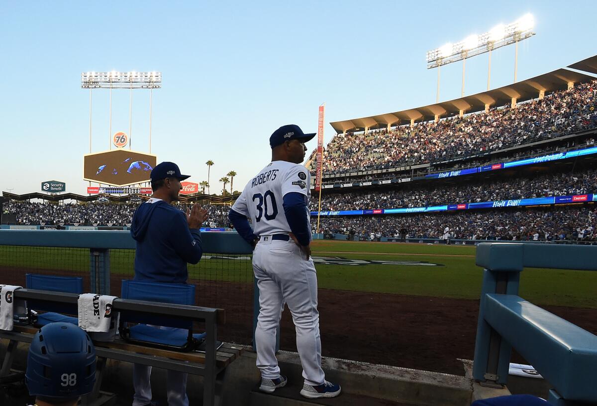 Dodgers manager Dave Roberts checks out a play during an NLDS game against the Senators on Oct. 9, 2019.