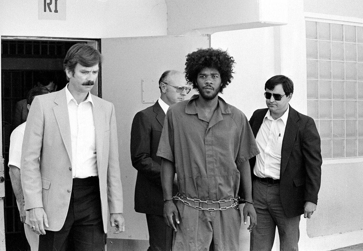 Kevin Cooper, center, shortly after his arrest in the slashing deaths of four people in Chino Hills. 