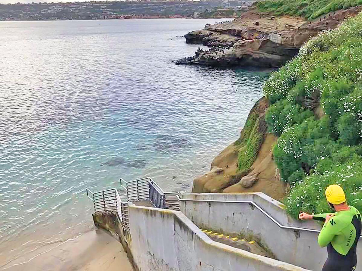 John Shannon is unusally the only swimmer heading toward La Jolla Cove, Friday, March 20, 2020. The state’s stay-at-home order allows for going out locally to exercise, if 6-feet social distancing is observed.