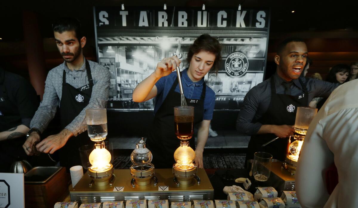 Starbucks workers prepare coffee during the company's annual shareholders meeting in Seattle in March.