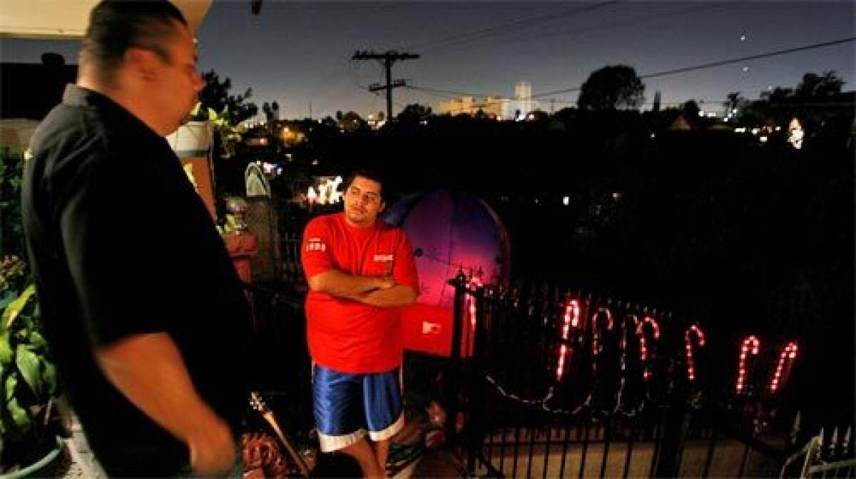 IN THE DARK: Fernando Diaz, left, talks with his nephew, Anthony Saucedo, in a part of Boyle Heights that has been without streetlights for two months because of wire thefts.