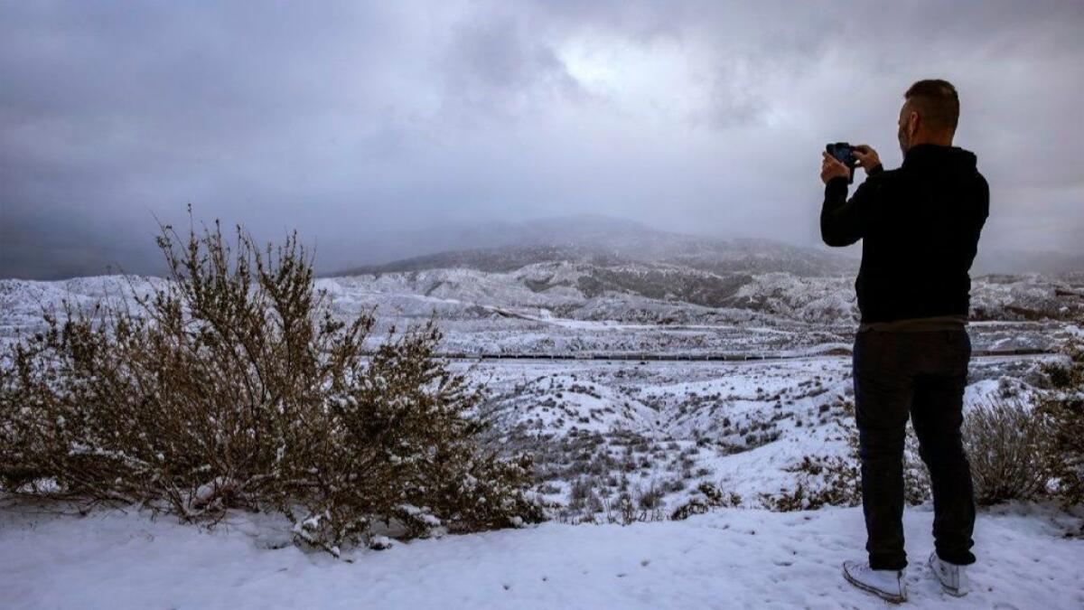 Greg Hunkle, 55, takes a picture last month at Cajon Summit on his way to Las Vegas. On Tuesday night, a new low pressure system could mean up to 4 inches of snow along the Grapevine stretch of the 5 Freeway.