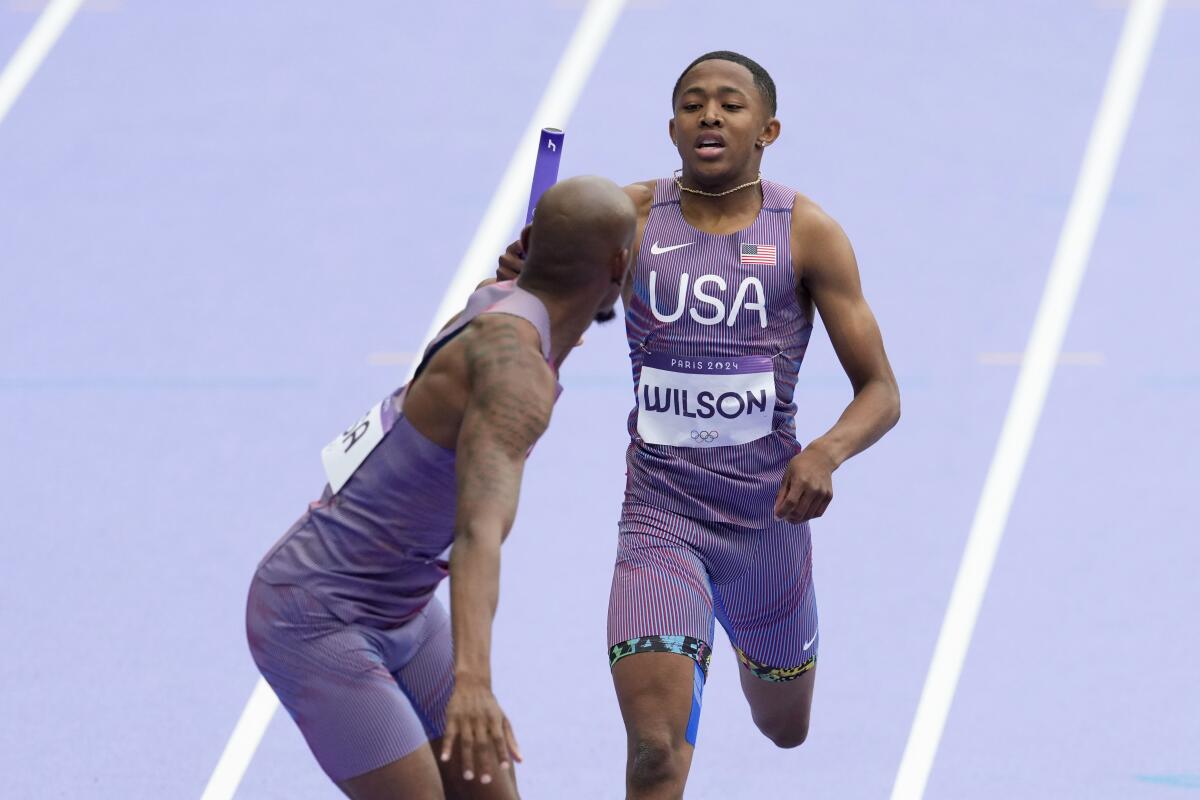 U.S. sprinter Quincy Wilson hands the baton to teammate Vernon Norwood in a men's 4x400-meter relay heat.