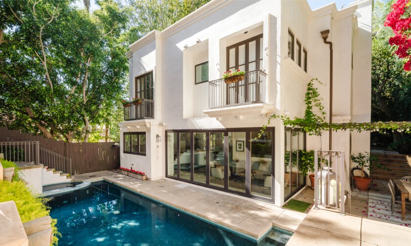 The rear of an upscale multiple-story home with a pool