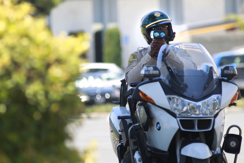 Los Angeles Sheriff's Deputy Elton Simmons aims his speed gun at a motorist in La Mirada in June 2012.