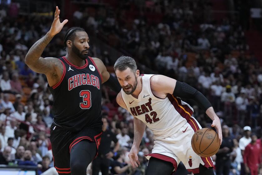 Miami Heat forward Kevin Love (42) drives to the basket against Chicago Bulls center Andre Drummond (3) during the first half of an NBA basketball play-in tournament game, Friday, April 19, 2024, in Miami. (AP Photo/Wilfredo Lee)