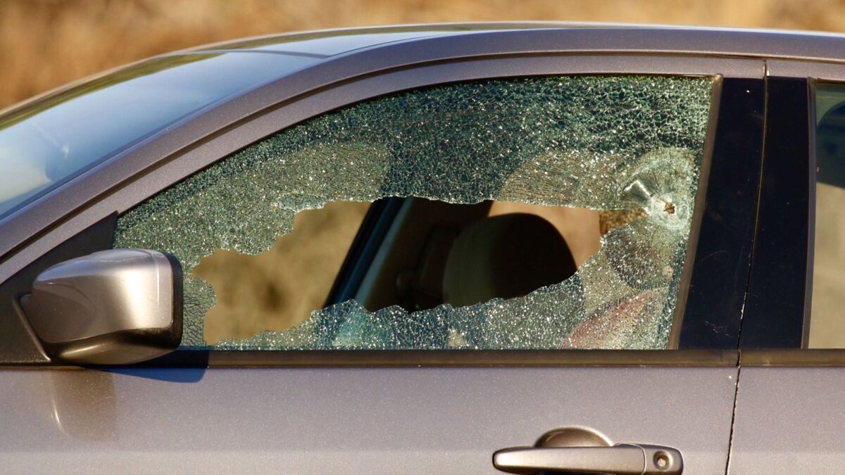 Detail photo of the driver's side window shows bullet hole.