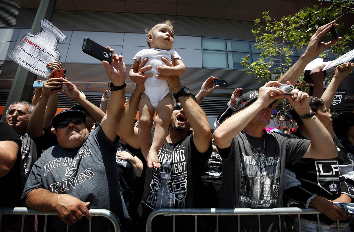 Fans celebrate along the Stanley Cup parade route in downtown L.A. The Kings have won two NHL titles in three seasons.
