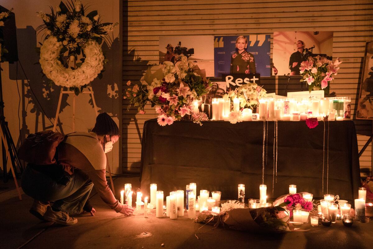 Jamie Frazer places a candle during a vigil for cinematographer Halyna Hutchins.