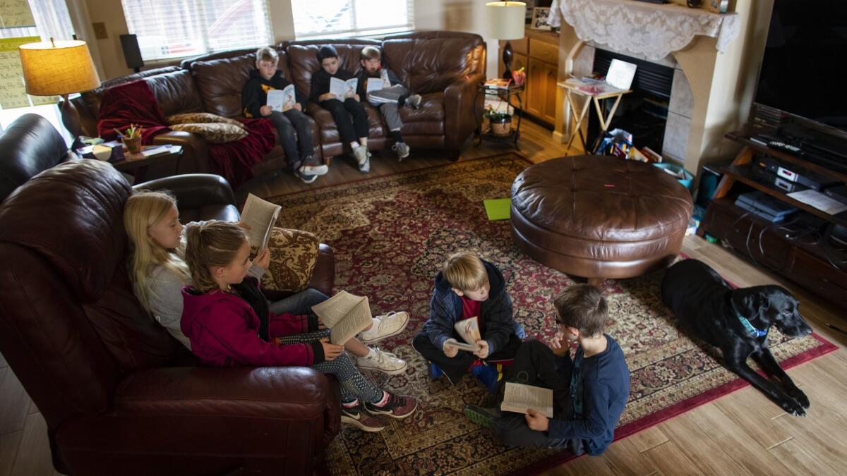 In Sheri Eichar's living room, children read "Charlotte's Web" during literature class while Eichar's dog, Shadow, looks on.