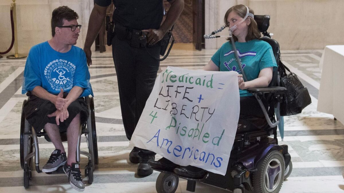 Protesters opposed to the Republican-crafted Senate healthcare bill are arrested by Capitol Police outside the office of Senate Majority Leader Mitch McConnell (R-Ky.) on Thursday.
