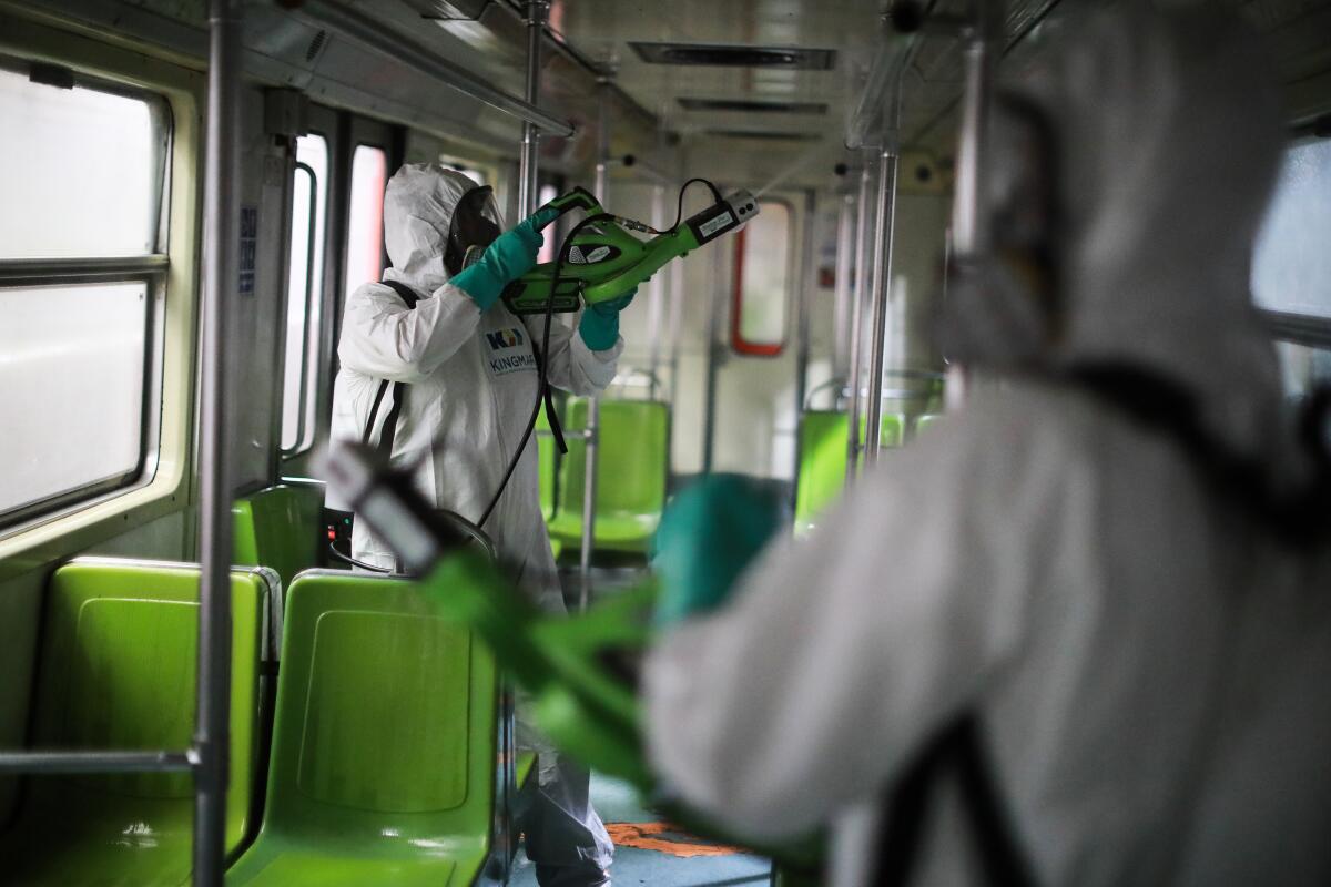 Workers disinfect a metro train car during a cleaning day at Coordinación de Mantenimiento Mayor Ticoman Coach Yard on March 18, 2020 in Mexico City, Mexico. The Mexico City Subway operates 12 lines with 195 stations, according to the official numbers, the system is used by more than 5 million people daily.