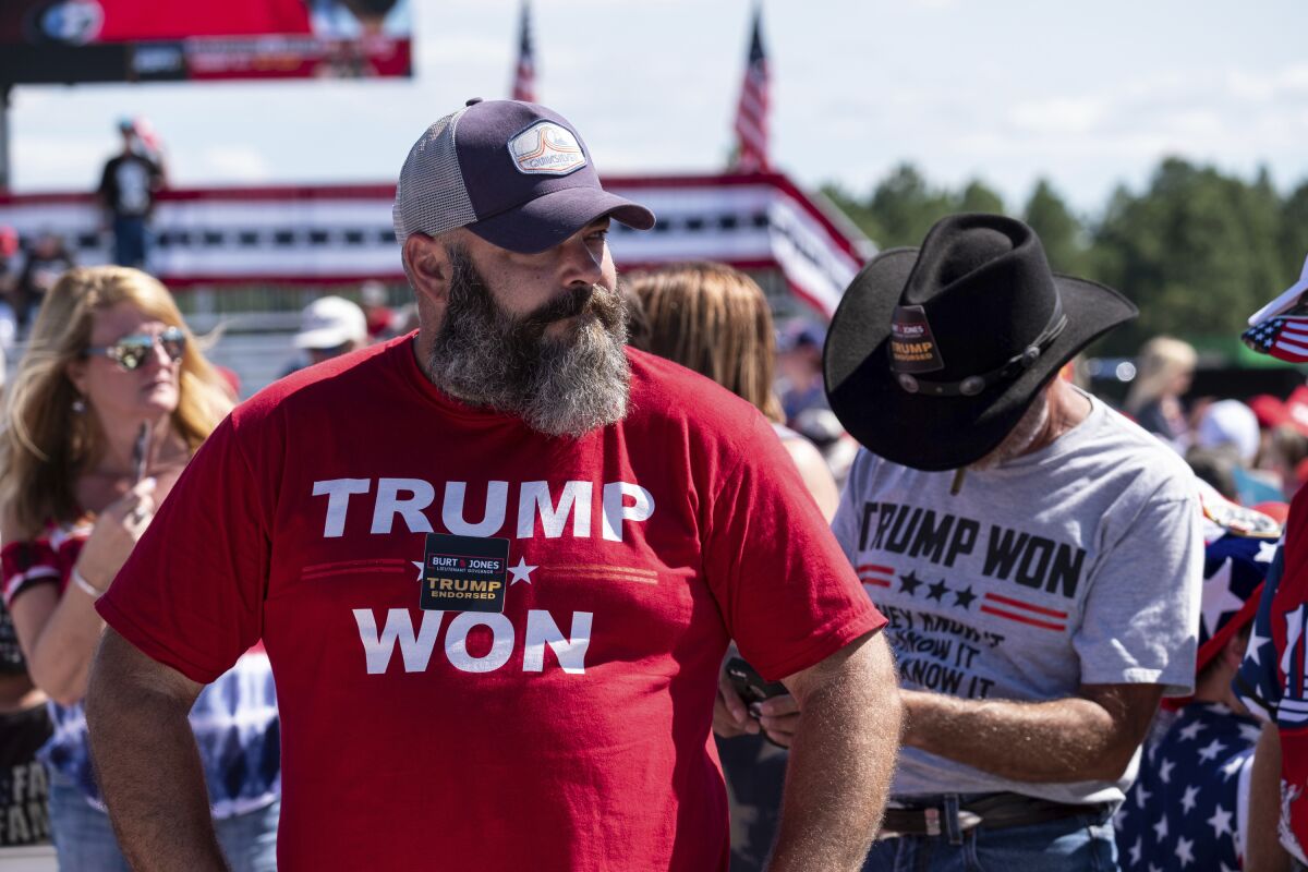 Two men wearing T-shirts reading "Trump won" at the site of an outdoor rally