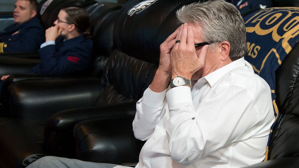 Larry Foles, father of the Nick Foles, covers his face as he watches his son play in a game in New York City.