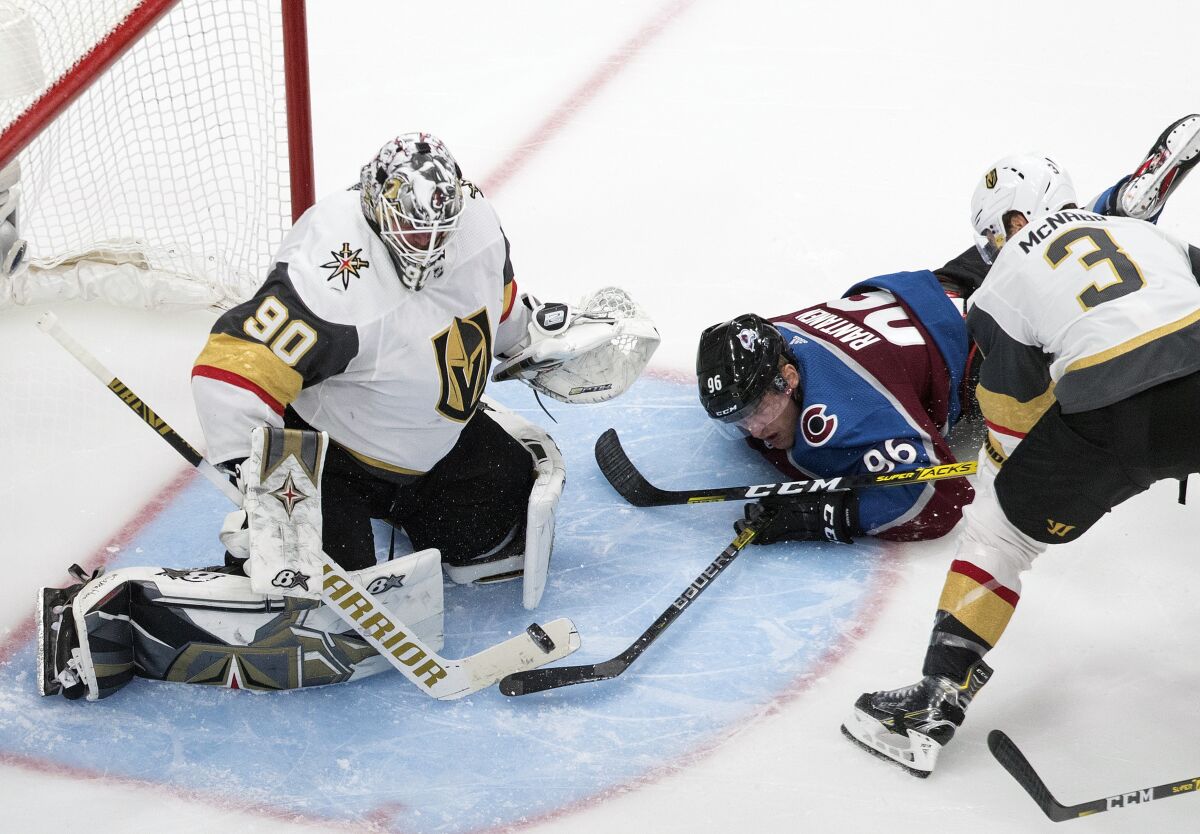 Colorado Avalanche's Mikko Rantanen (96) tries to get the puck past Vegas Golden Knights goalie Robin Lehner (90) during the third period of an NHL Stanley Cup qualifying round game in Edmonton, Alberta, Saturday, Aug. 8, 2020. (Jason Franson/The Canadian Press via AP)