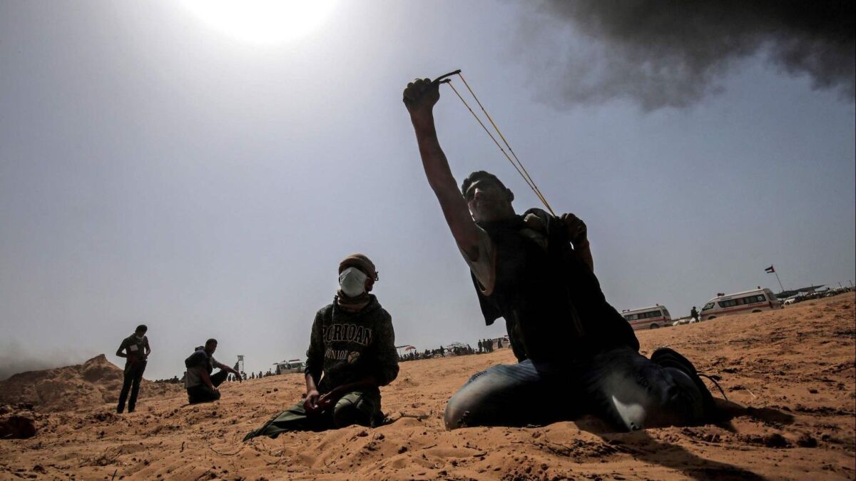 A Palestinian protester uses a slingshot during clashes with Israeli forces near the border with Israel.