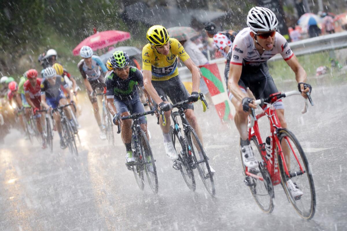 Chris Froome, in yellow leader's jersey, rides in heavy rain duing Stage 9 of the 2016 Tour de France.