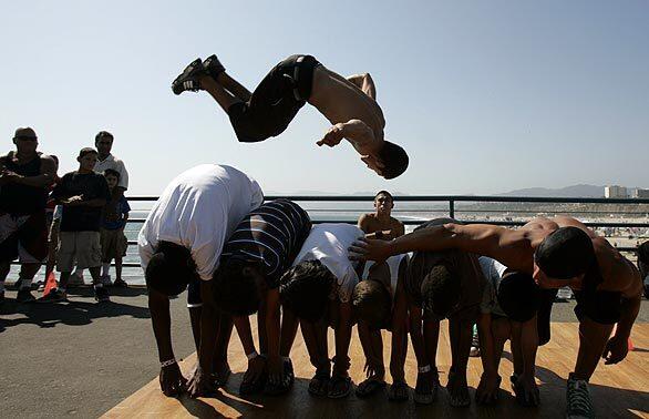 Lanny Markasky, a member of the street dance group Mala Vida, makes a jump during a tumbling performance at the Santa Monica Pier.