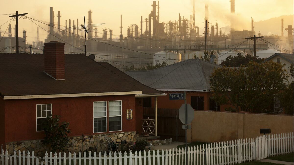The Phillips 66 refinery looms over a neighborhood in the Wilmington neighborhood of Los Angeles. A fee increase adopted by Southern California officials will pay for a greater share of the costs of regulating toxic air pollution from refineries and other facilities.