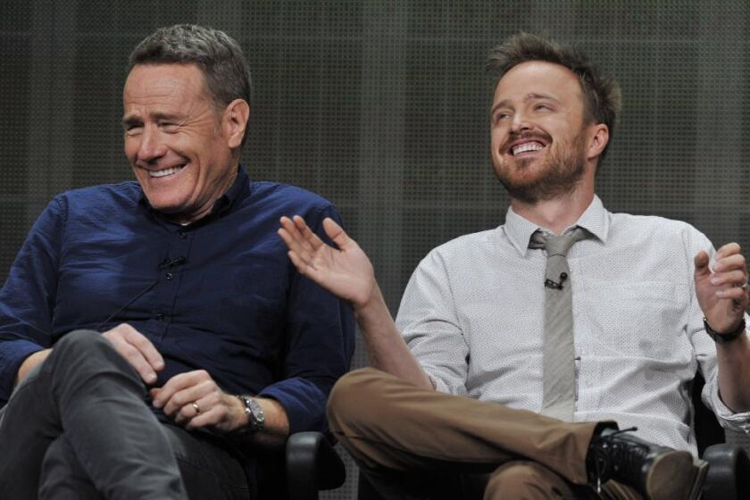 Bryan Cranston, left, and Aaron Paul, cast members in the television series "Breaking Bad," share a laugh onstage during AMC's Summer 2013 TCA press tour at the Beverly Hilton Hotel.