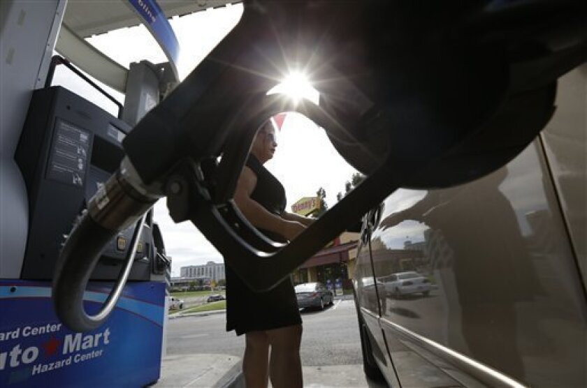 Lorena Delara fills up her tank with gasoline at a gas station Friday, Oct. 5, 2012, in San Diego. A 20-cent jump overnight in California gas prices has put the state ahead of Hawaii for the nation's most expensive gas. (AP Photo/Gregory Bull)