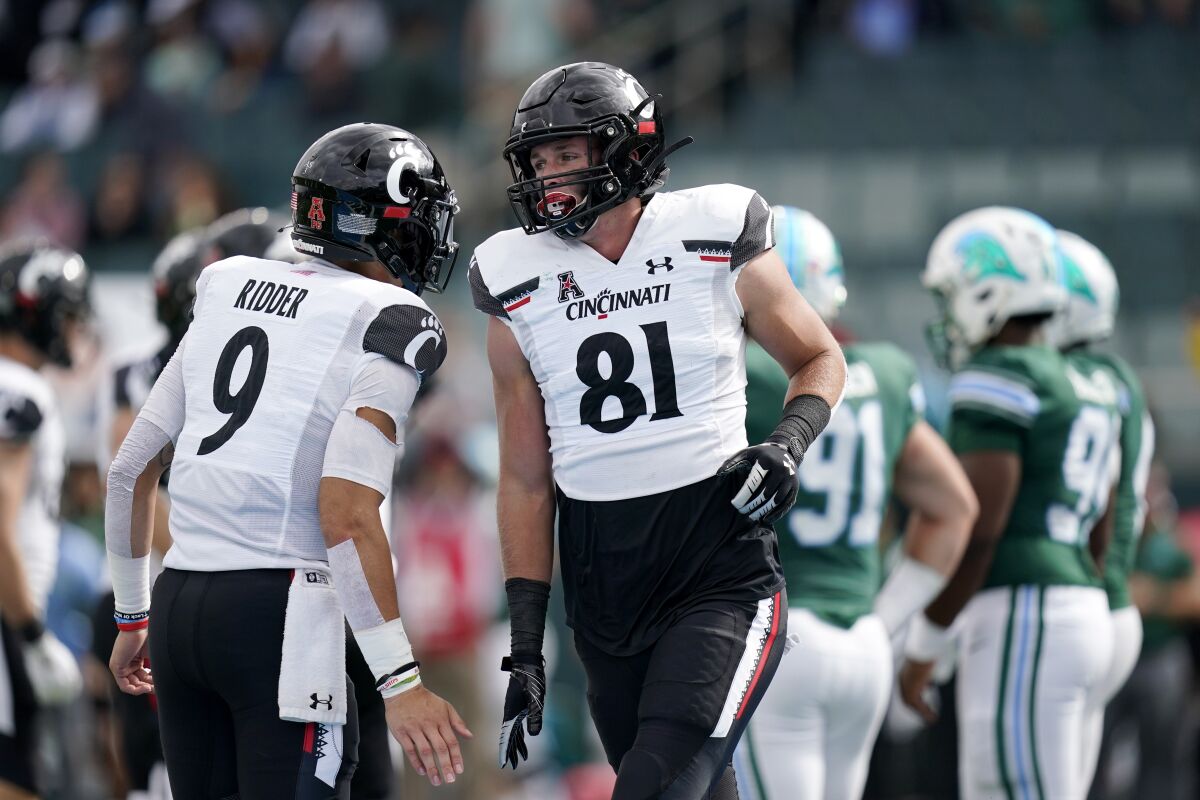 Cincinnati tight end Josh Whyle (81) celebrates his touchdown reception with quarterback Desmond Ridder (9) during the first half of an NCAA college football game against Tulane in New Orleans, Saturday, Oct. 30, 2021. Cincinnati won 31-12. (AP Photo/Gerald Herbert)