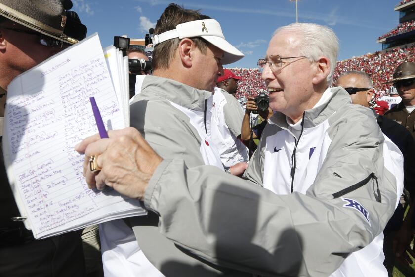 Kansas State Coach Bill Snyder, right, is congratulated by Oklahoma Coach Bob Stoops after the Wildcats' 31-30 victory over the Sooners on Saturday.