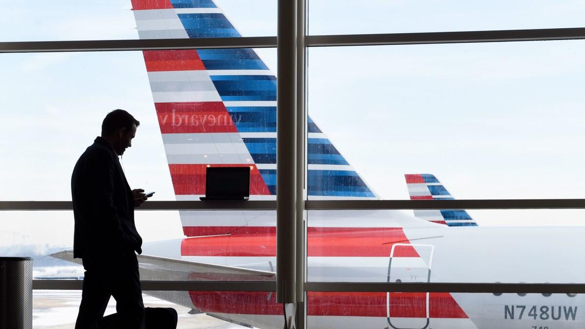 American Airlines jets sit parked at their gates at Ronald Reagan Washington National Airport. A computer error that allowed too many pilots to schedule vacation during the Christmas holiday is expected to cost the carrier $10 million, an industry expert said.