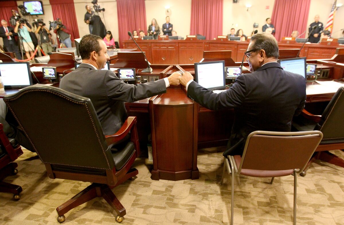 City Councilmen Mitch Englander, left, and Gil Cedillo celebrate the passage of sweeping legislation to require earthquake retrofits on 15,000 buildings in Los Angeles during a council meeting in Van Nuys.