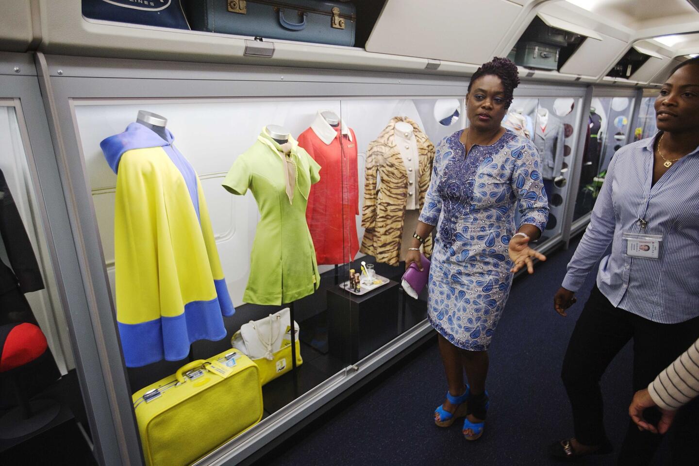 Vintage flight attendant uniforms are showcased in an exhibit at the Delta museum's grand reopening.