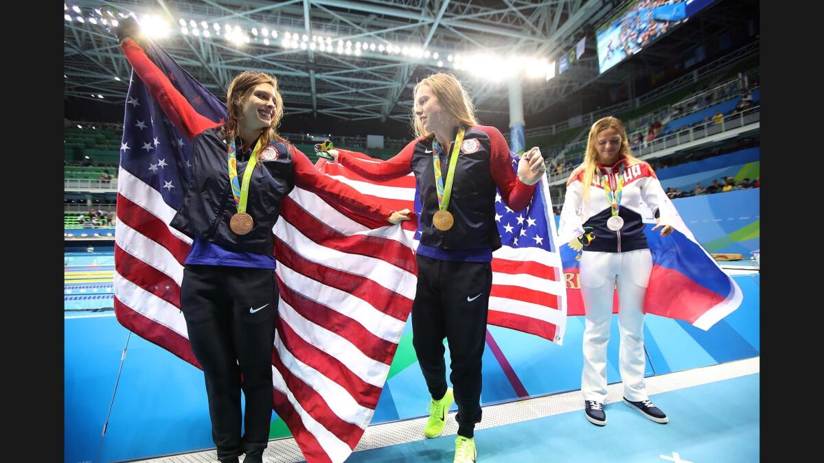 Women's 100m Breaststroke winners, Katie Meili (Bronze), left, Lilly King (Gold) and Yulia Efimova of Russia parade in front of photographers after the medal ceremony at the 2016 Olympics.
