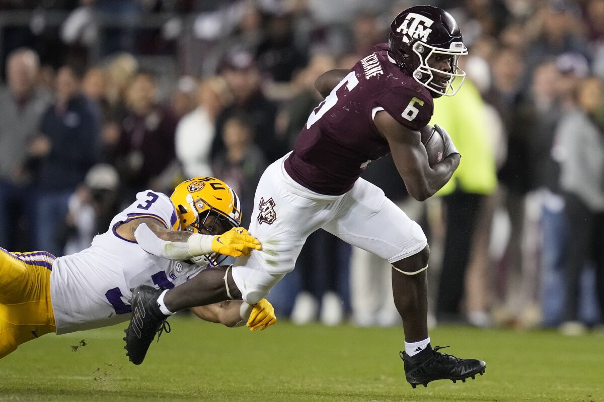 Texas A&M running back Devon Achane (6) breaks free from LSU safety Greg Brooks Jr. (3) during the first quarter of an NCAA college football game Saturday, Nov. 26, 2022, in College Station, Texas. (AP Photo/Sam Craft)
